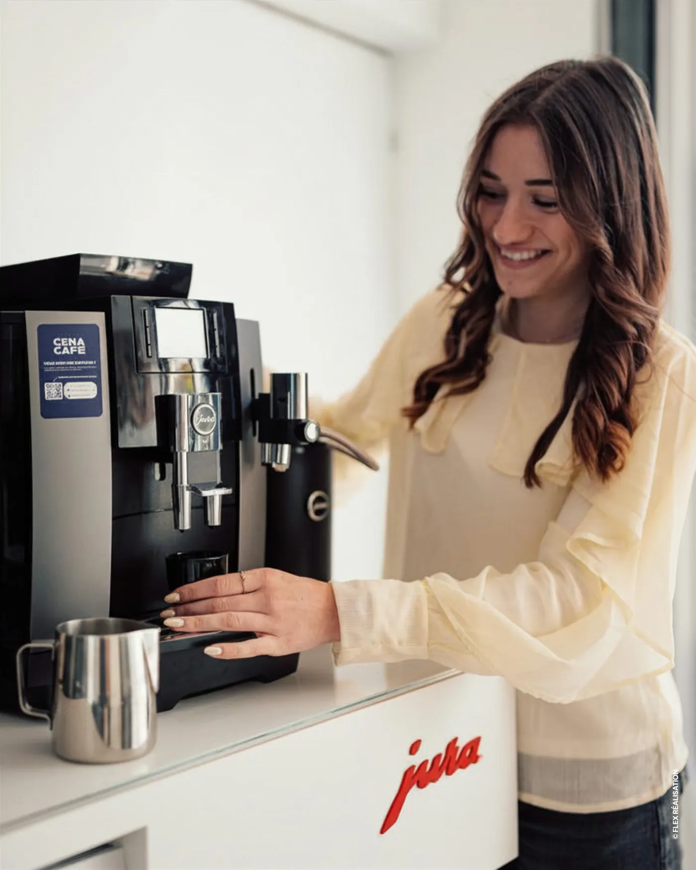 Collaboratrice préparant un café sur une machine Jura équipée du sticker QR code Cena Café